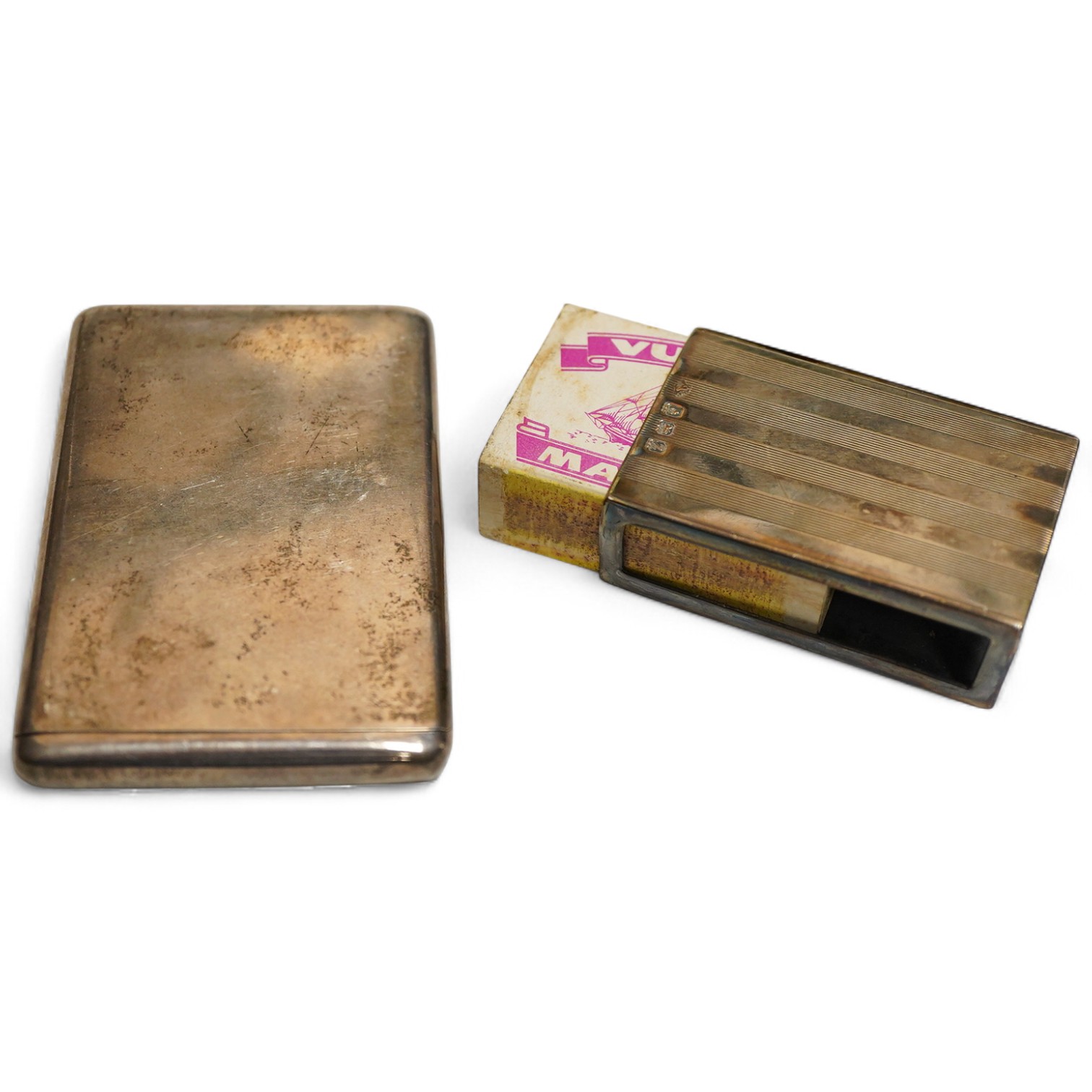 An Edwardian silver card case, London, 1903, Sampson Mordan & Co, plain rectangular form with sprung hinged cover, length 8.7cm., interior gilt together with a matchbox cover with linear engine turned decoration Birmingh